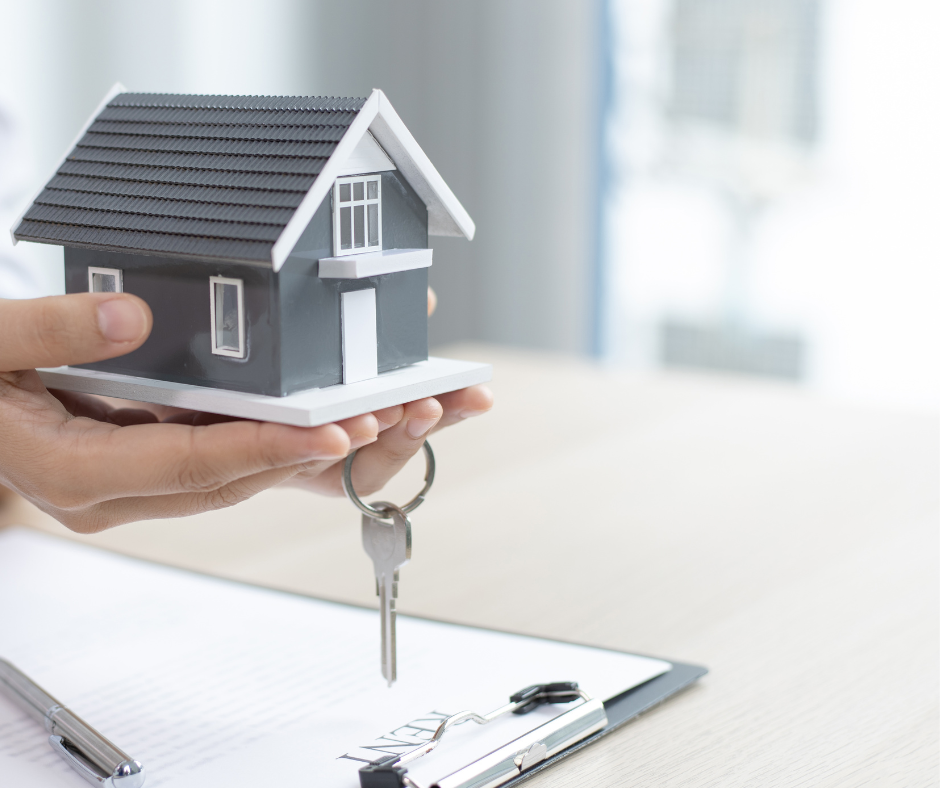 Miniature house in hands with keys