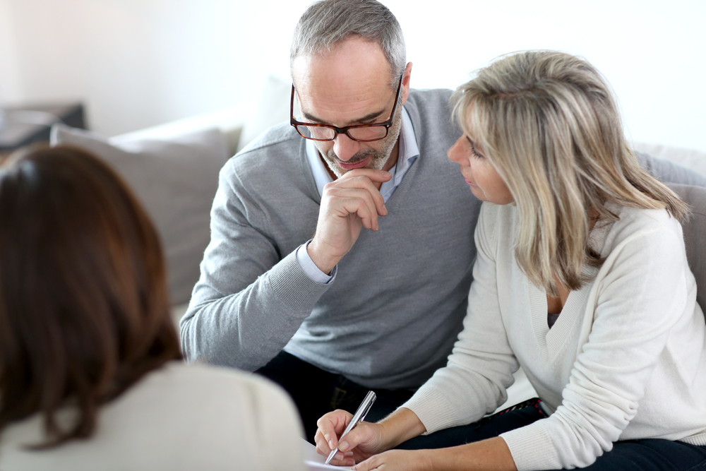 Senior couple meeting and reviewing paperwork. 