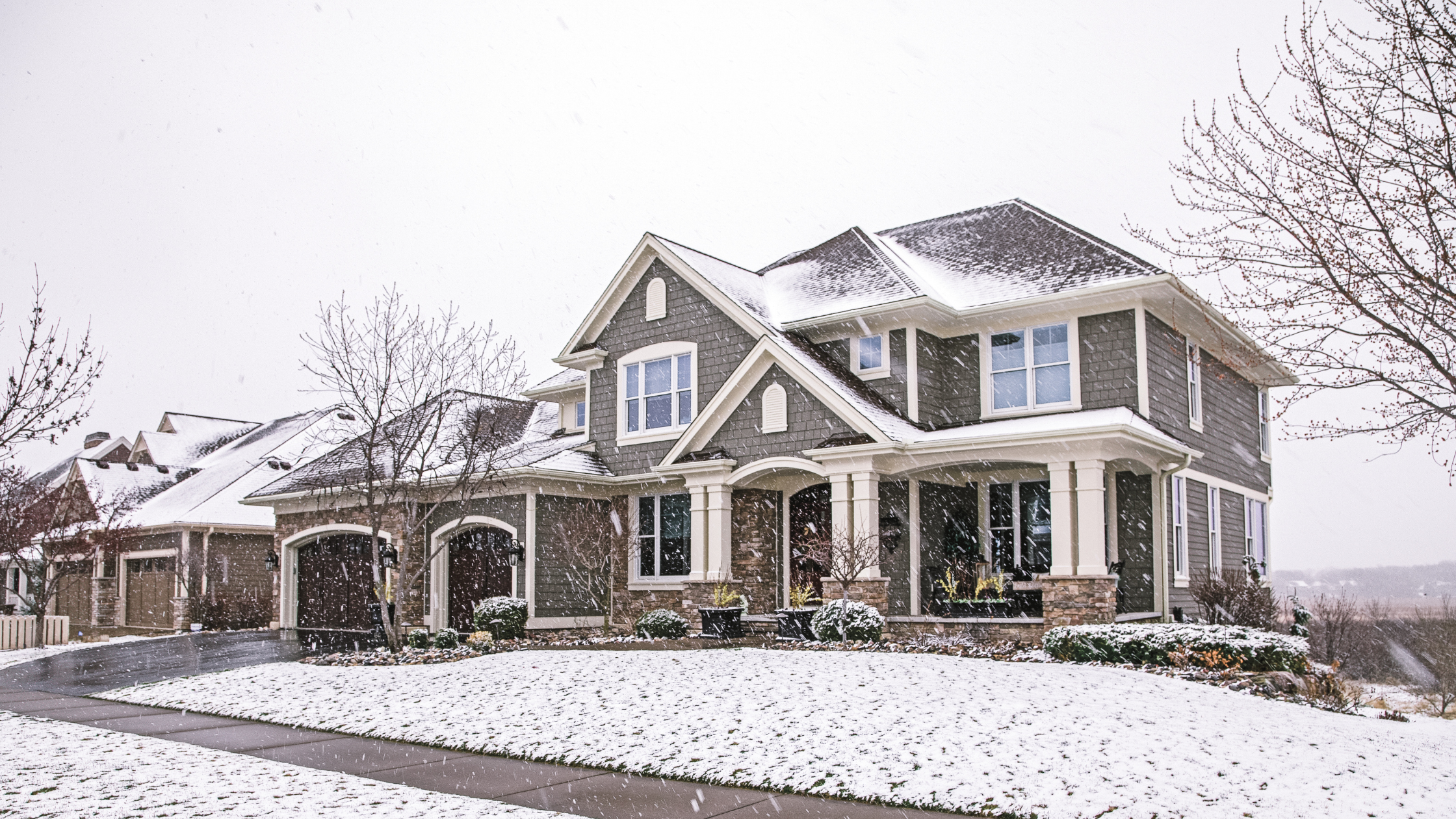 Snow covered front yard with two story home